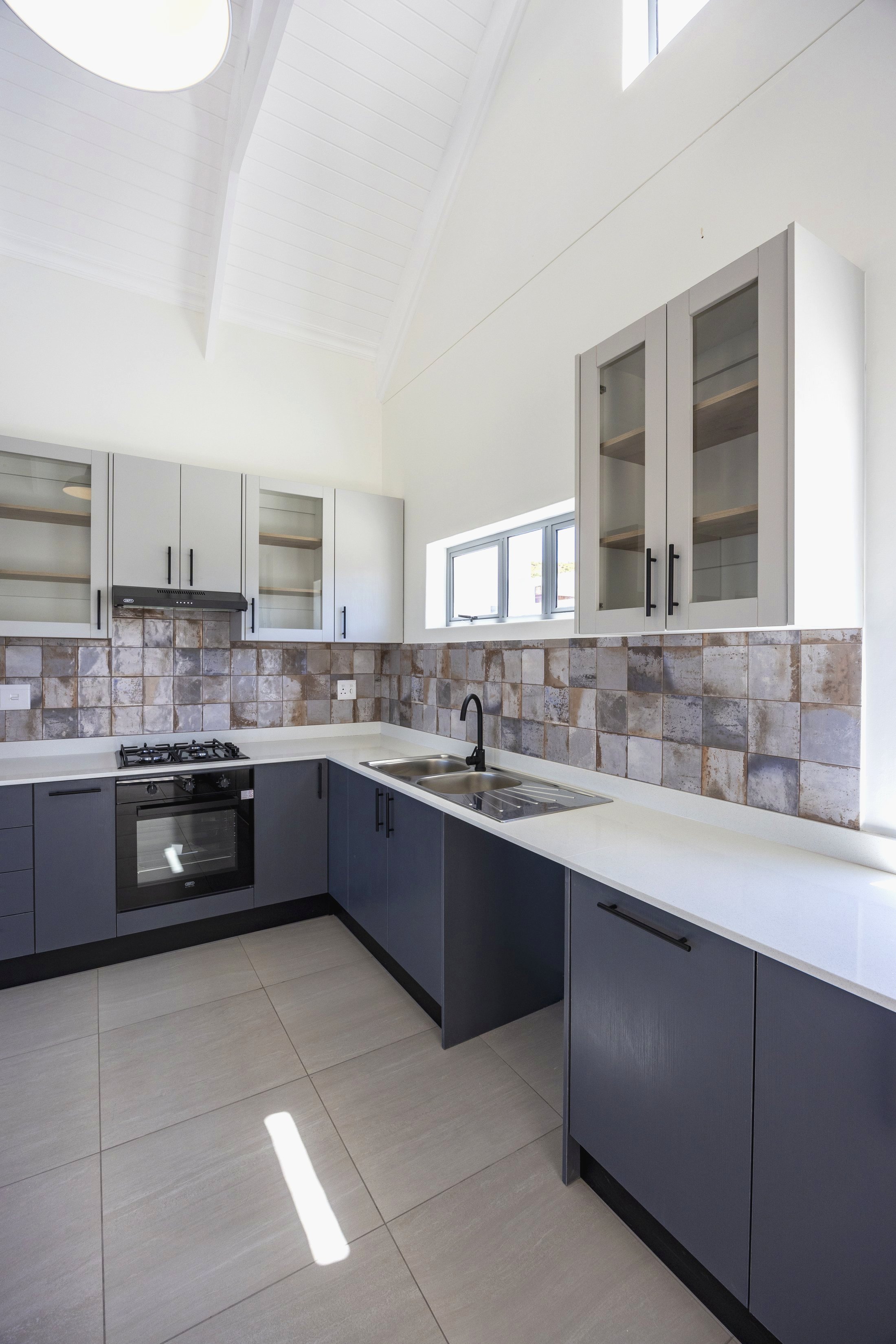 Kitchen with navy cabinetry and decorative tile